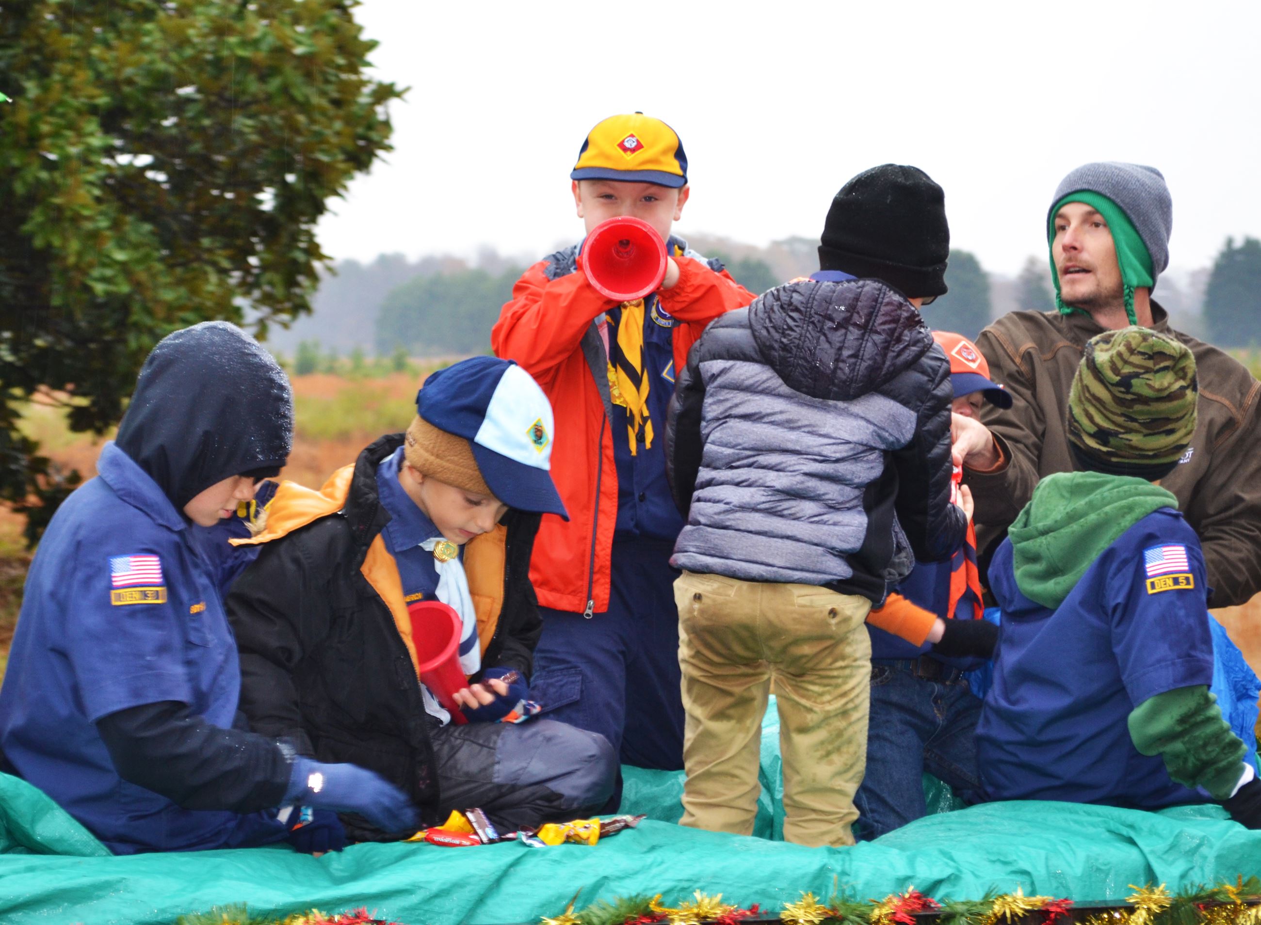 A child blows a horn from a parade float