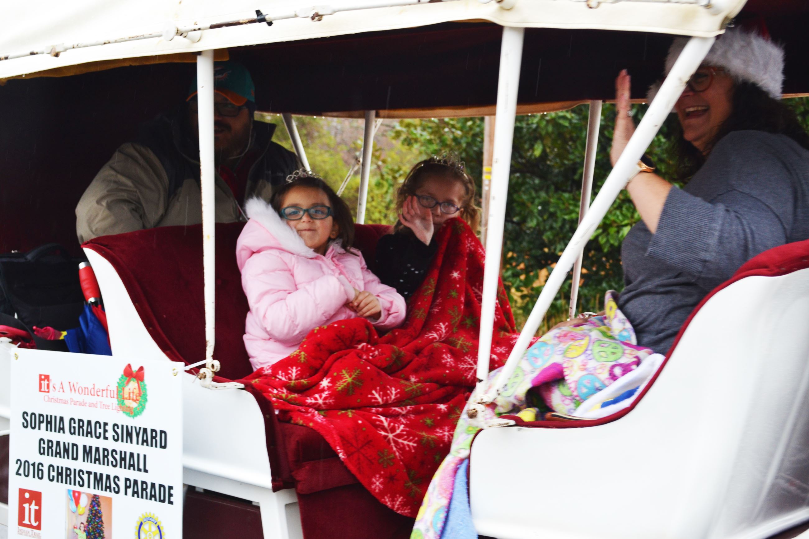 The parade Grand Marshal rides by in her carriage